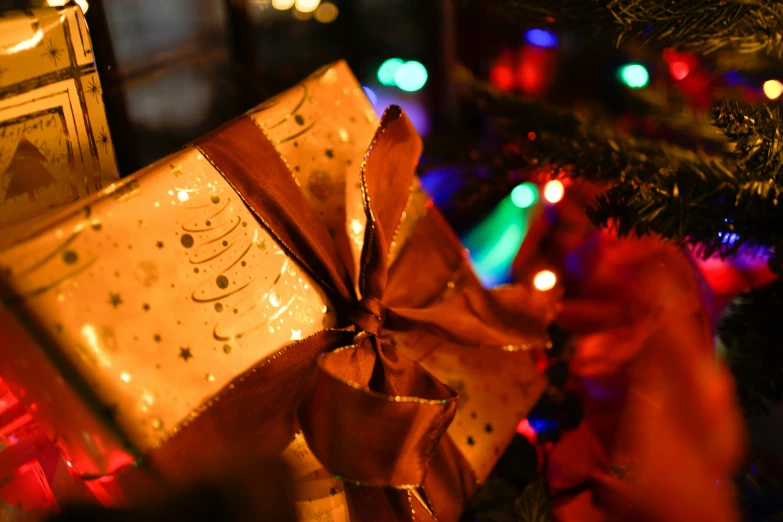 presents under a lit christmas tree decorated with lights