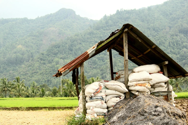 a house built over sandbags in front of mountains