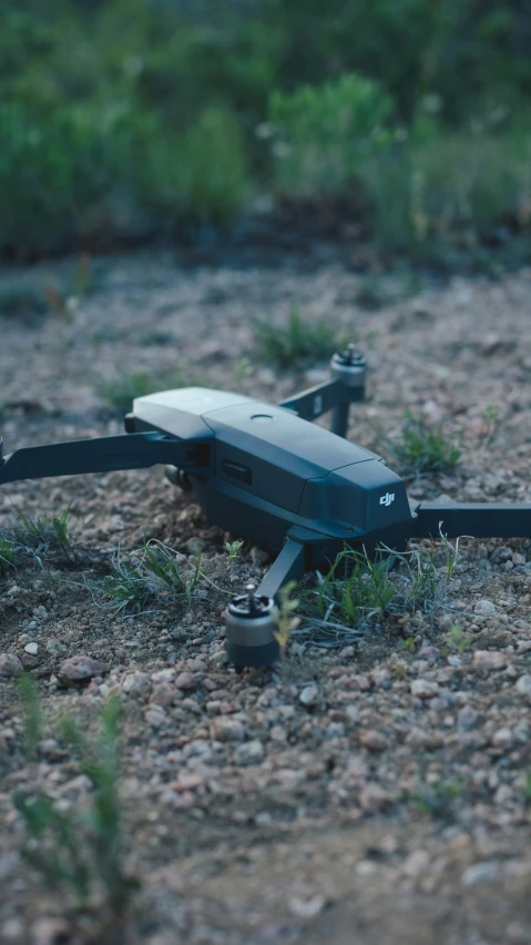 the small, black remote controlled hovering device is laying on the ground