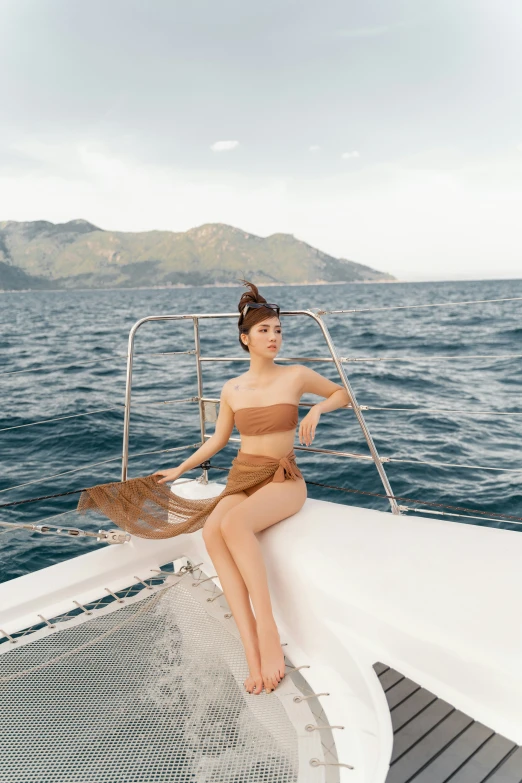 a woman sitting on the back of a boat wearing a bikini