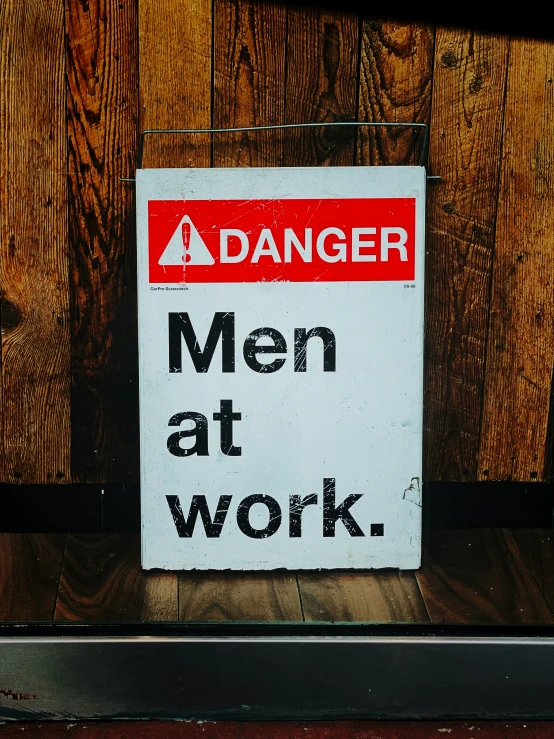 a sign warning that men at work is being taken from a door