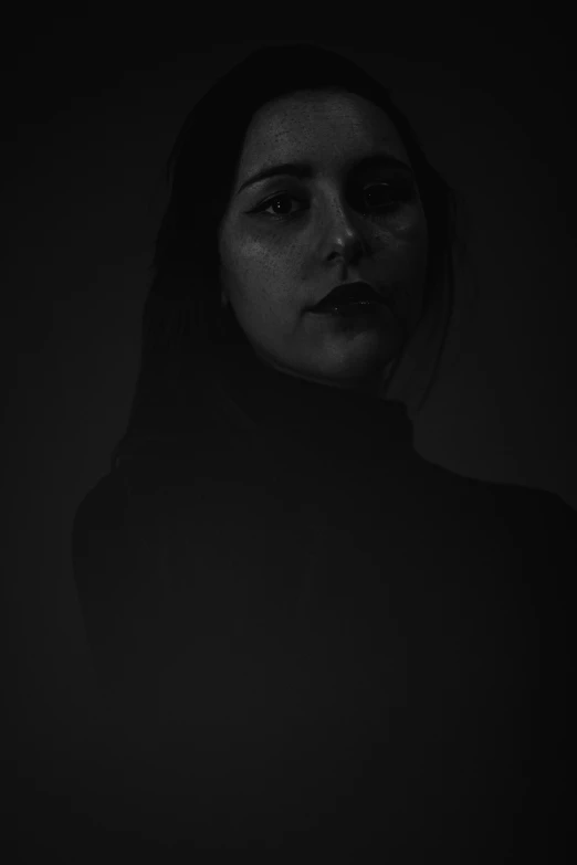 a woman staring into the camera with the dark background