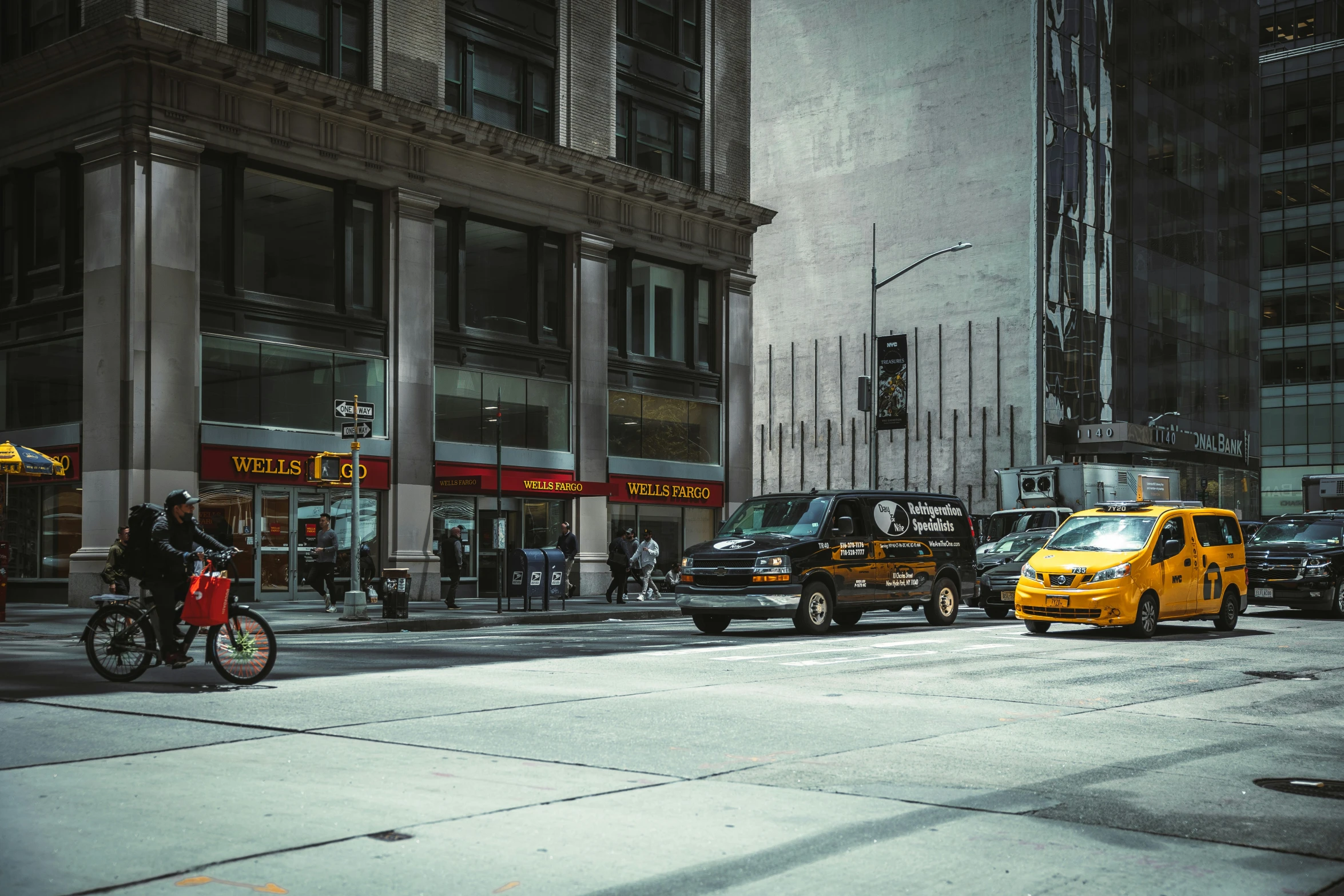 a yellow taxi cab drives down a city street