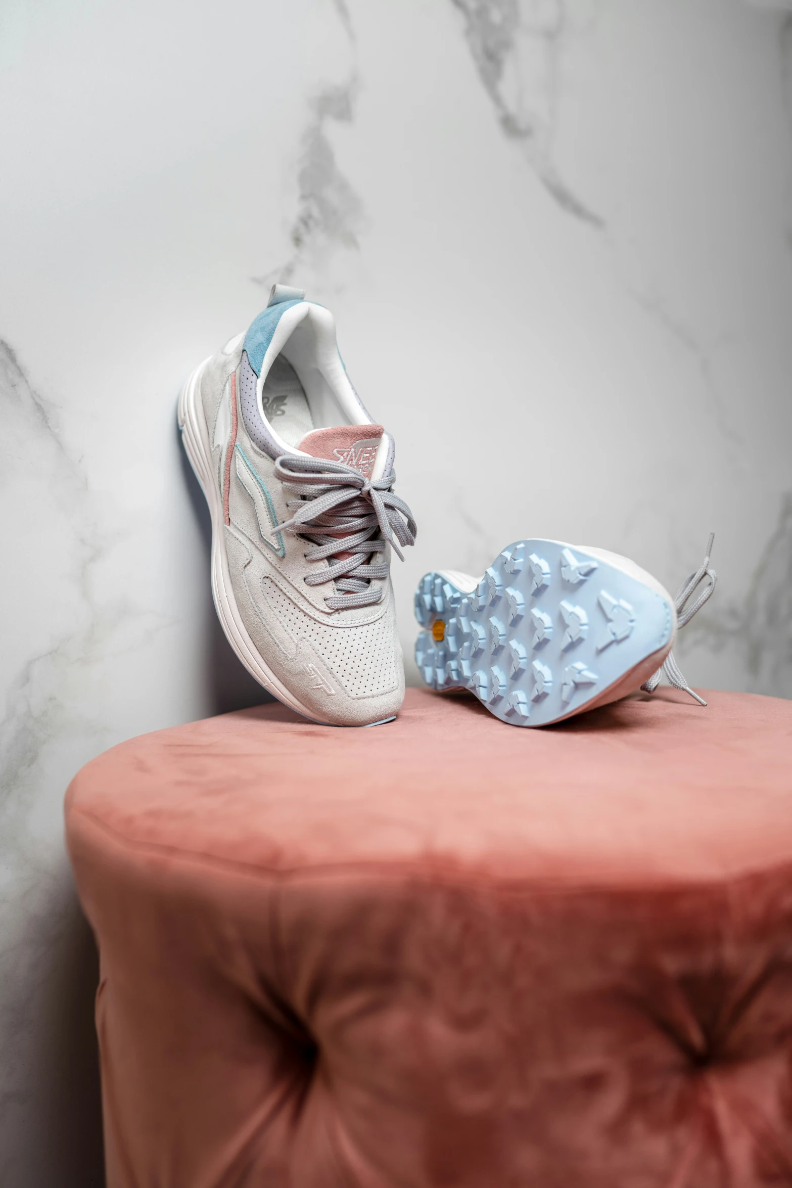 two nike shoes sit on top of an ottoman