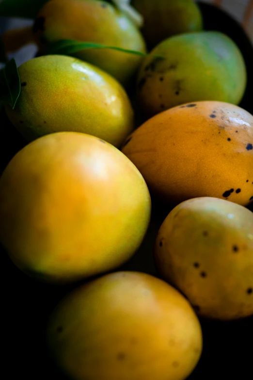 mangos and apples in a bowl with one on the side