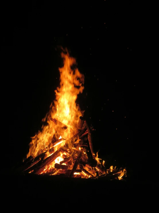 the burning logs of fire in the night sky