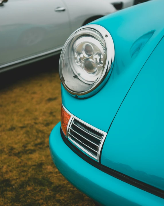 a close up of a blue car with two other cars behind it