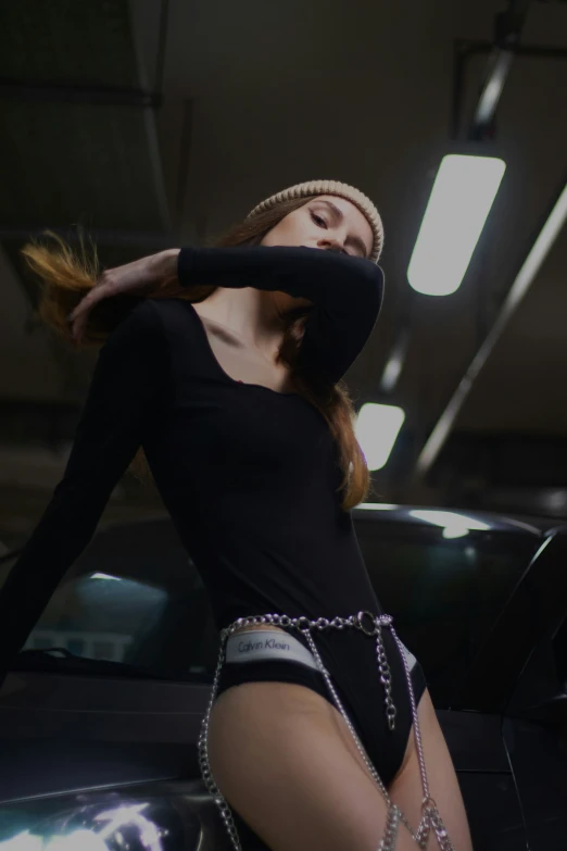 a  young woman wearing lingerie standing next to a car