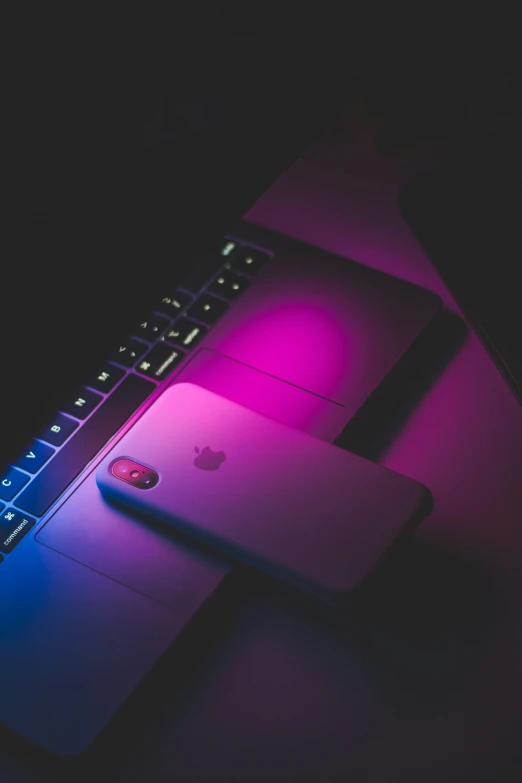 a black computer keyboard with pink and purple light