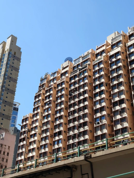 two tall buildings against a blue sky, near a bridge