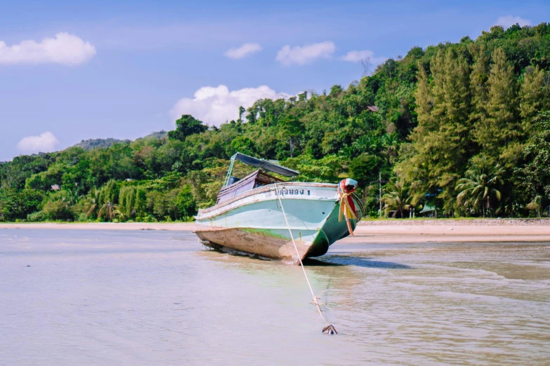 a boat tied to the beach by a rope