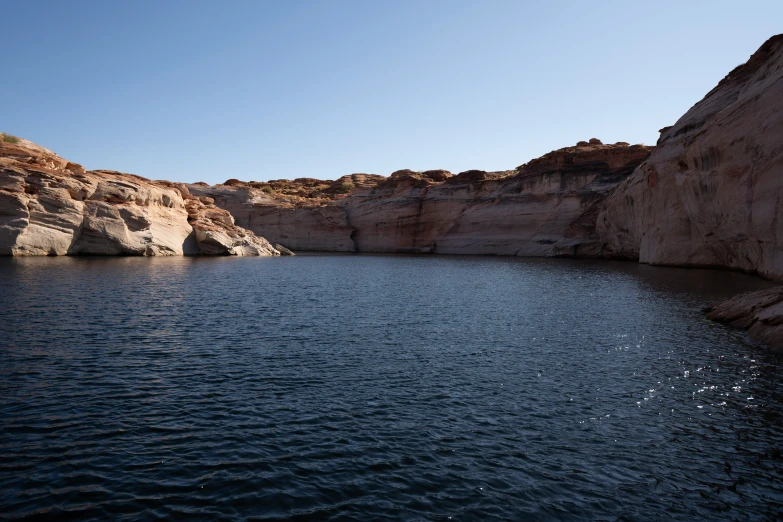 a body of water next to a rocky hillside