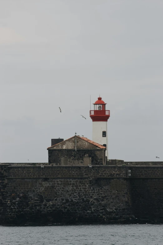 the old lighthouse was built on top of the brick wall near the water