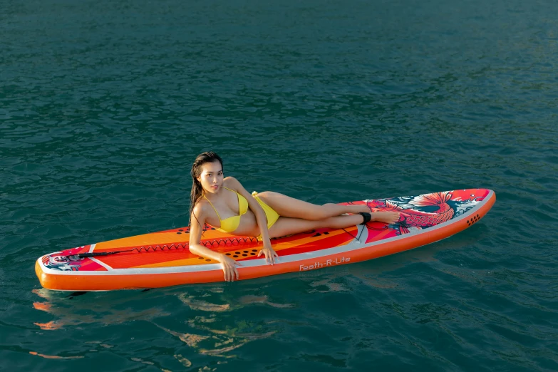 a  in a bikini paddleboarding on water