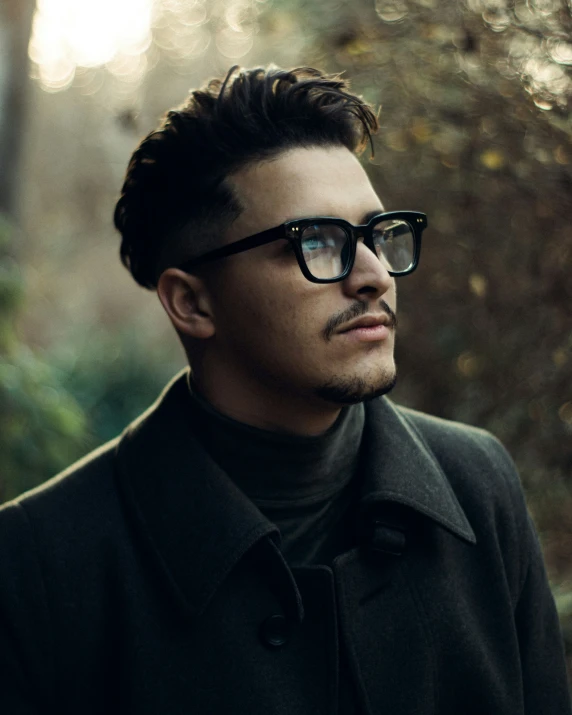 a man with a black pea coat and glasses on