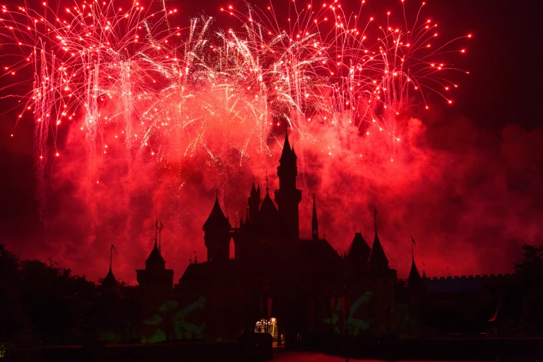 a dark scene with fireworks and a castle at night