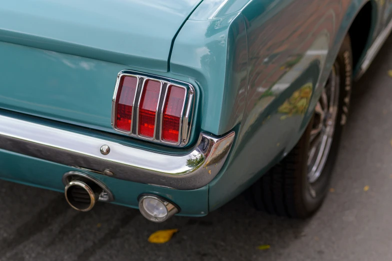 the taillight on a vintage turquoise mustang car