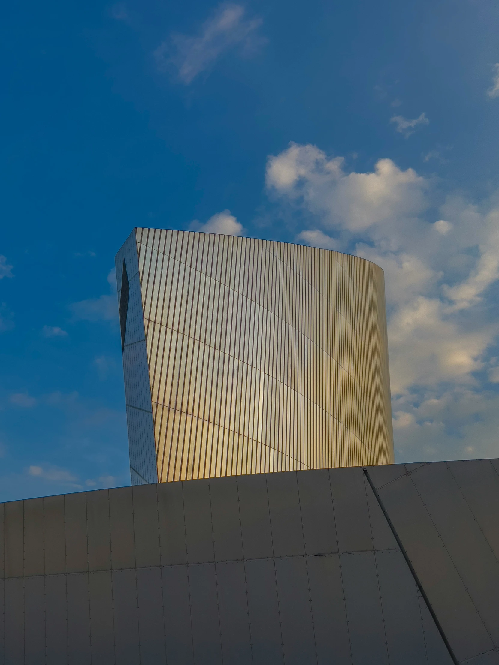 a large modern building with a very wide corner in front