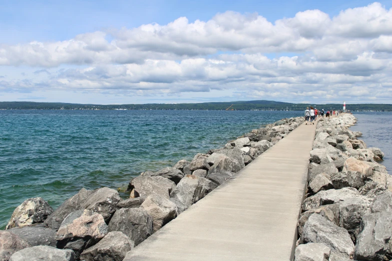 a wooden path leads along the water along a rocky shoreline