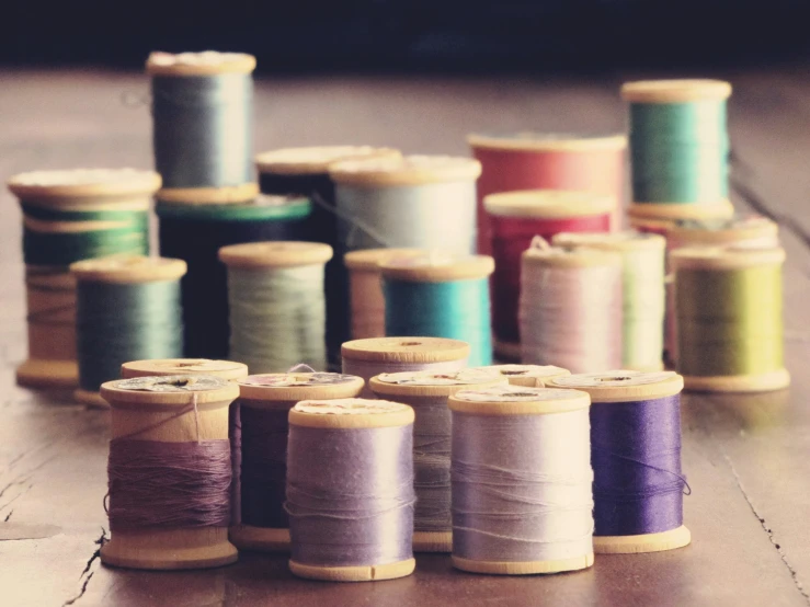 a row of spools of thread sit on the floor