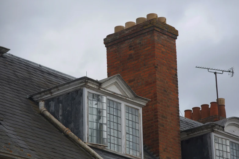 a couple of chimneys sitting above windows on top of a building