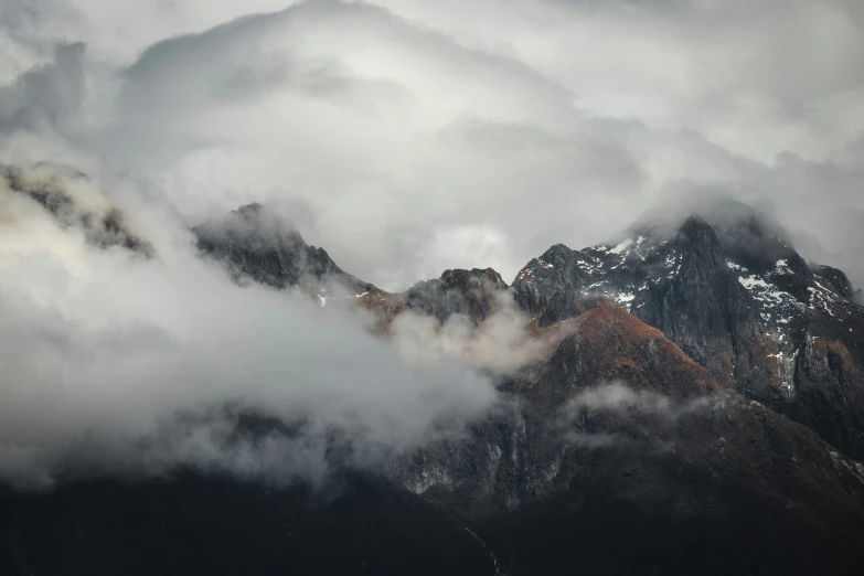 a number of clouds surrounding mountains