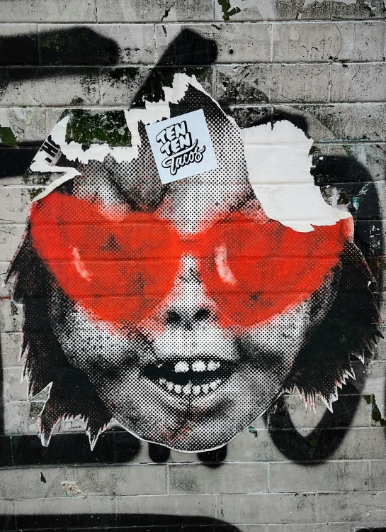 a street wall with a drawing of a clown wearing a red nose