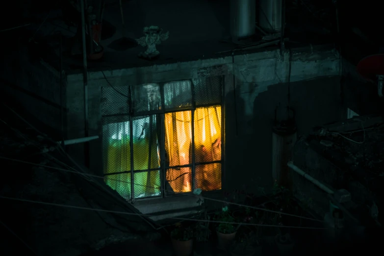 a couple stands inside of a very dark room with a large window open