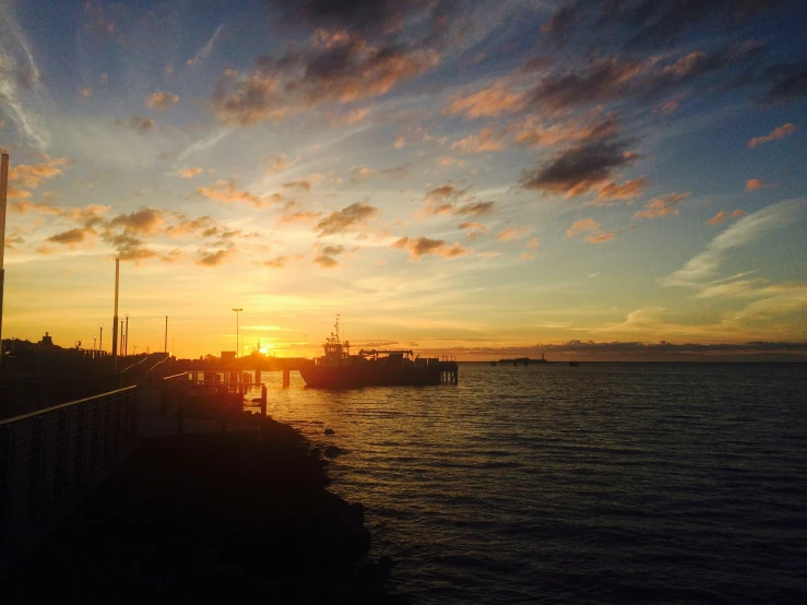 a bright sun is setting over the water