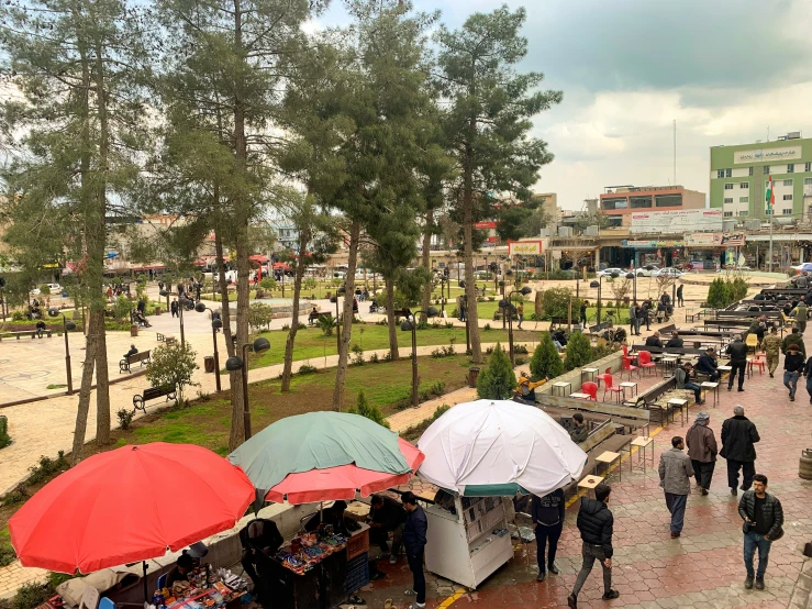 people walking and walking through a shopping area under umbrellas