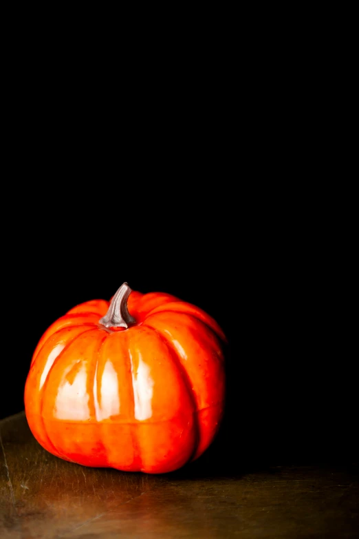 a black back ground and a light shining on a pumpkin