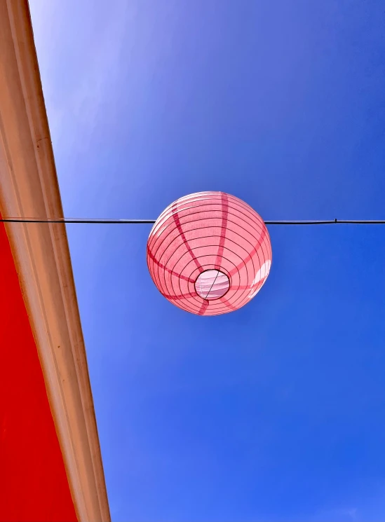 a red lamp in the sky and a red building