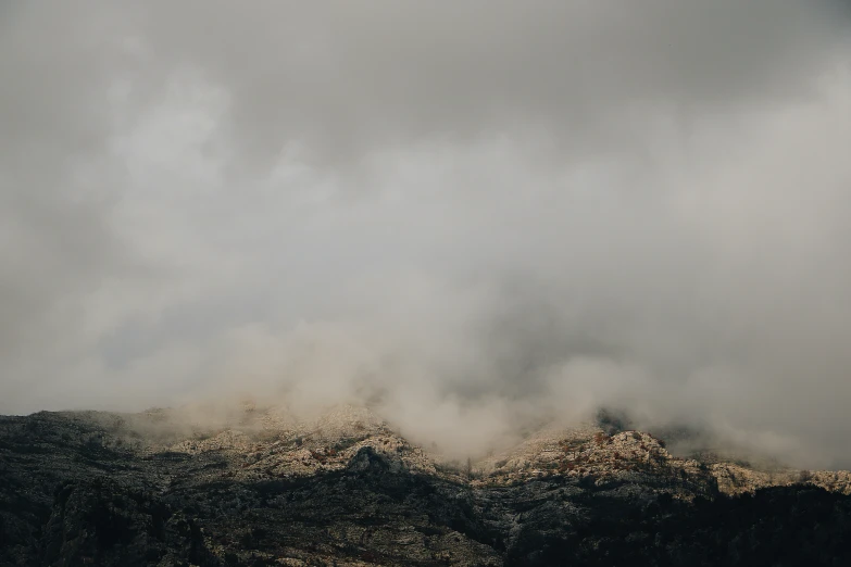 a mountain range is obscured by thick, foggy clouds