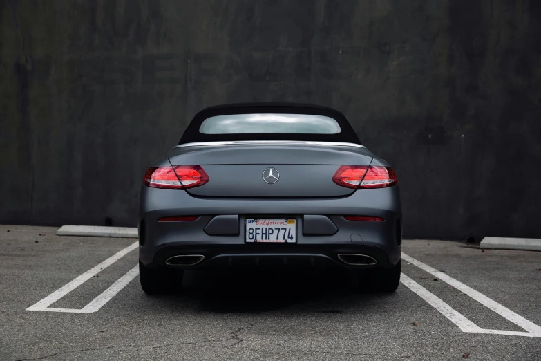 a grey sports car is parked in a lot