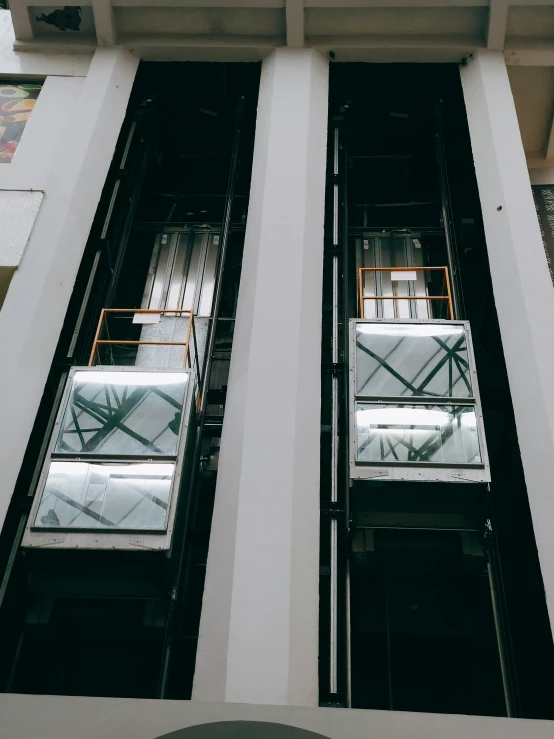 two glass windows with white trim are seen in front of a building