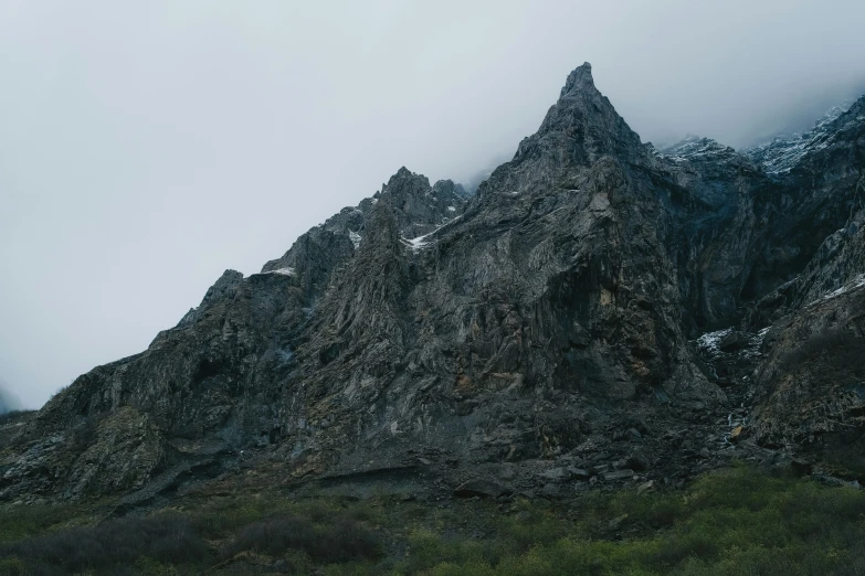 a rock formation with green grass below