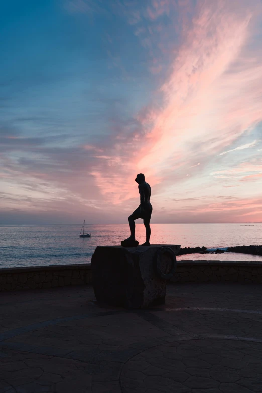 a person standing on the edge of a wall overlooking a body of water