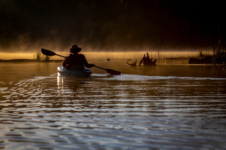 a person kayaking through the calm waters at dusk