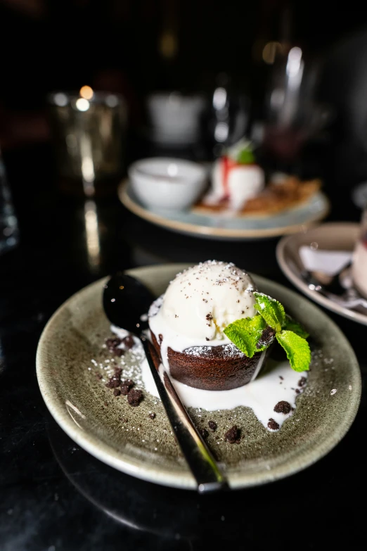 a black table with an ice cream desert and spoon
