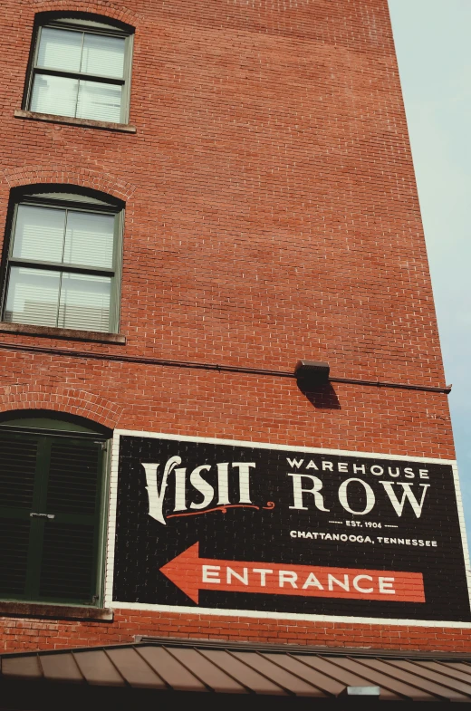 a red brick building with a visit row sign attached to it