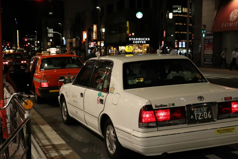 a line of cars traveling down a city street at night