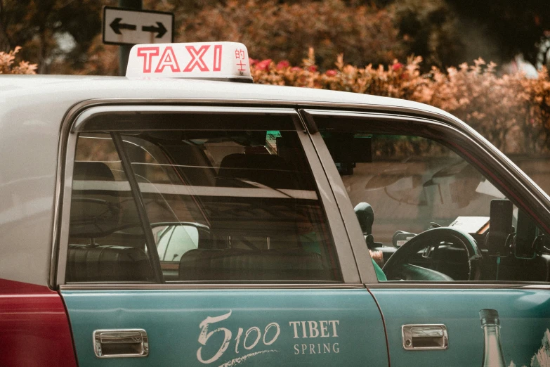 a green taxi is driving on the street