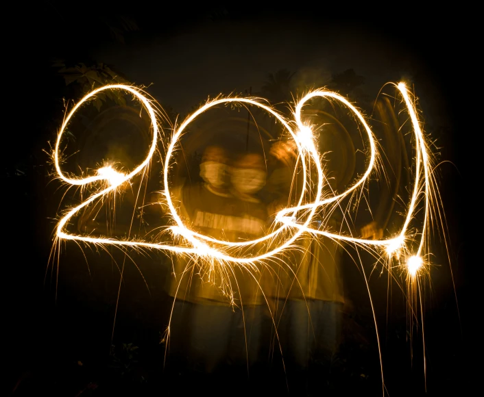 a couple is pictured at night with their hands held back in the air and sparklers in the air