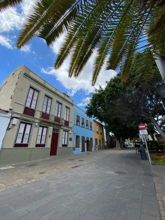 an empty street is lined with buildings that are blue and brown