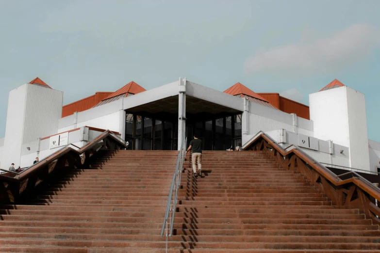 three people walking up a very steep stairway