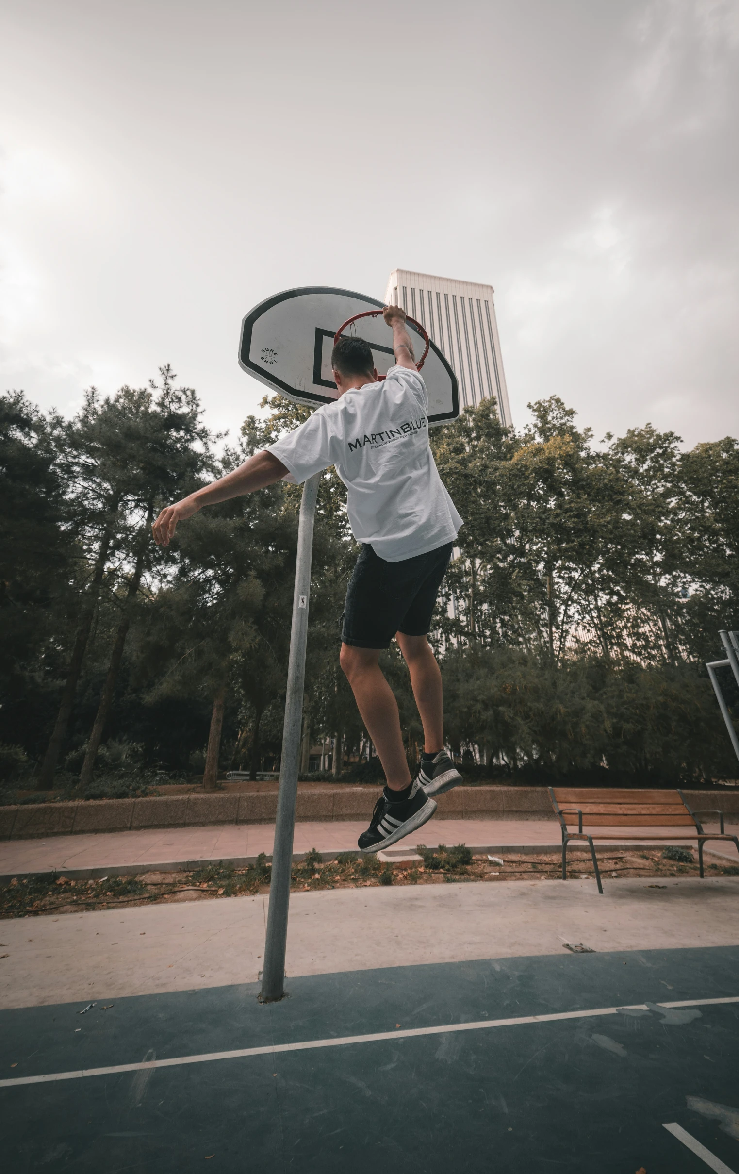 a boy jumping up into the air on a basketball