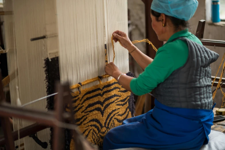 a woman working with a large weaving pattern