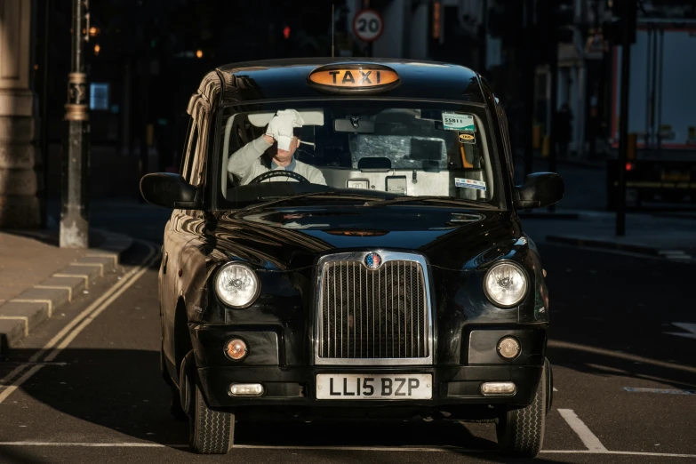 a taxi with an attendant's seat and cab pulled up to a traffic light