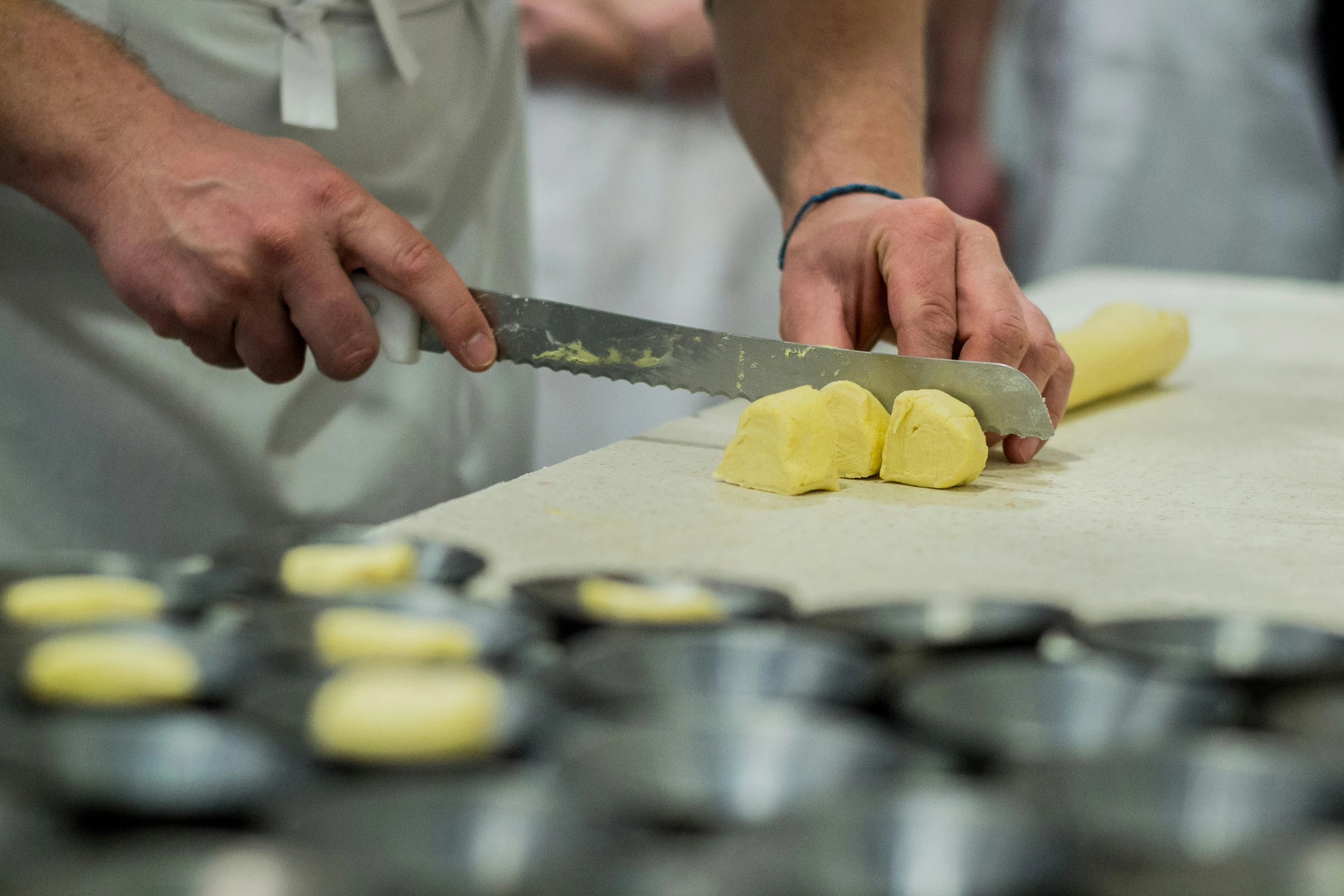 two people  up a yellow potato with a knife