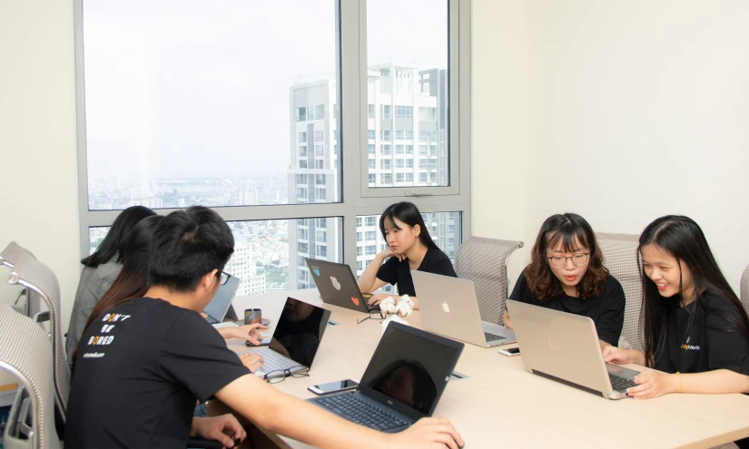 group of people looking at laptops in a conference room